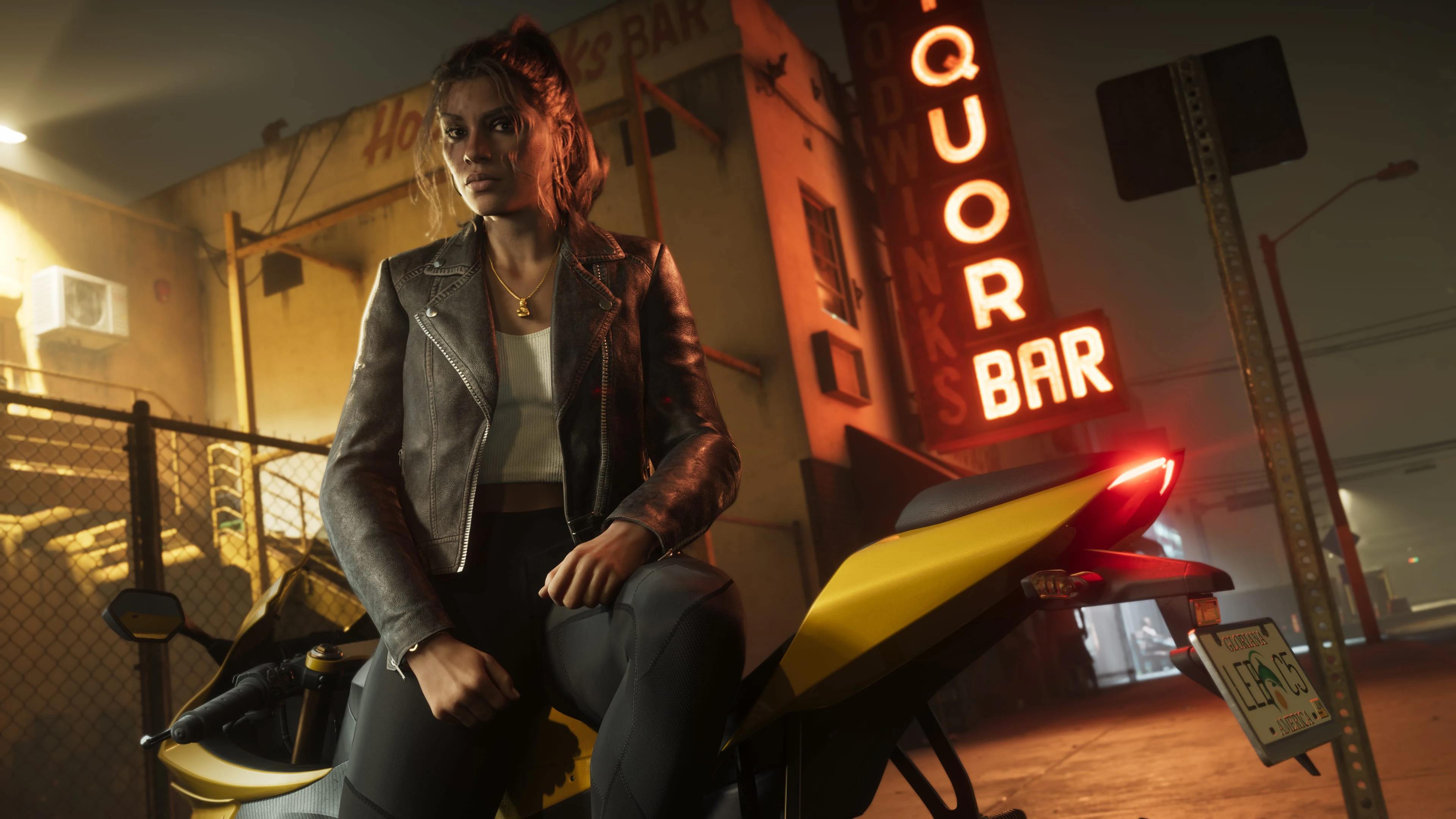 An adult Valiant performer seated on a yellow motorcycle outside a neon bar